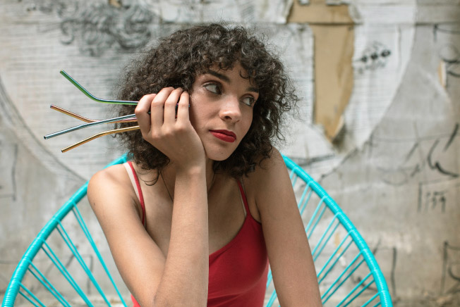 woman holding straws contemplating dry sockets after oral surgery