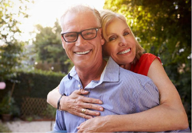 senior coupls hug and smile after learning about the link between gum disease and heart health