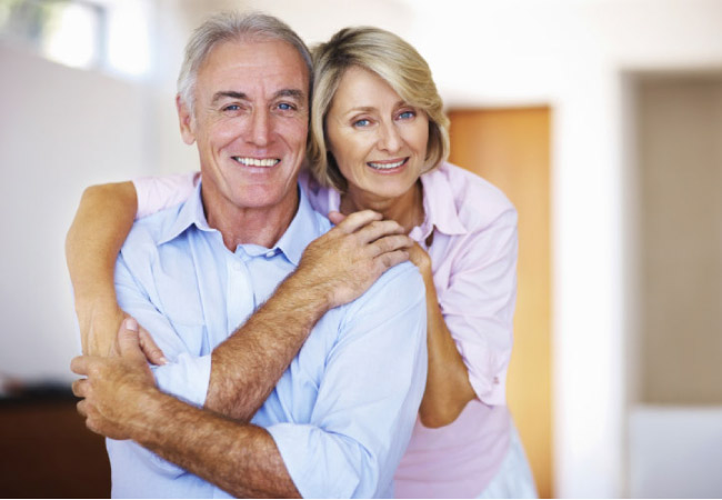 senior couple hug and smile after learning about dental crown options