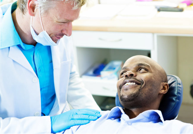 man sits in the dentist chair discussing restorative options with the dentist