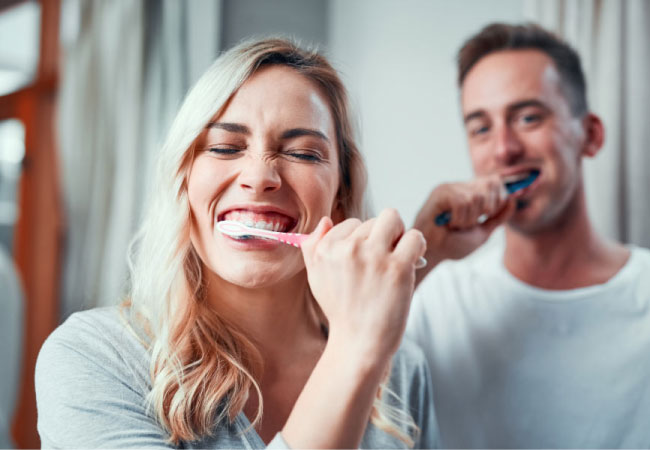 young couple brushing their teeth together