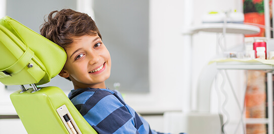 young boy sitting in a dental chair