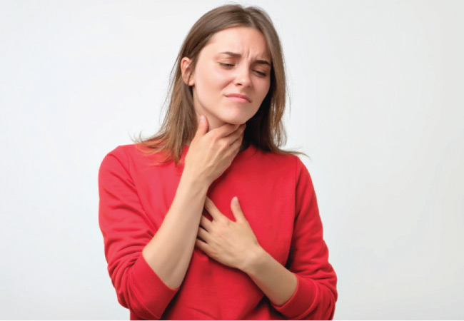 woman holds her throat and chest with a respiratory issue